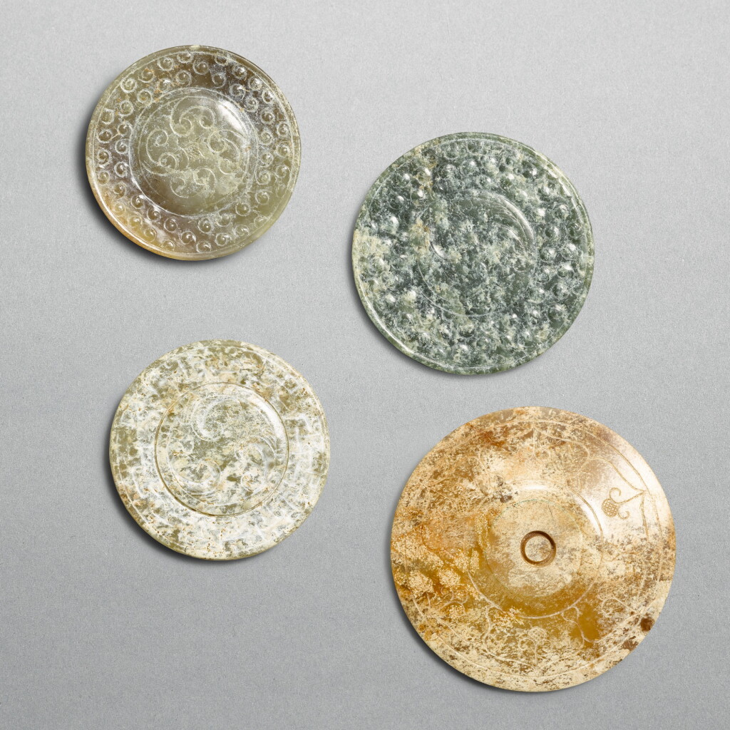 View full screen - View 1 of Lot 753. Four celadon jade sword pommels, Han dynasty | 漢 青玉旋渦紋劍首三件 及 柿葉紋劍首一件.