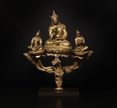 View full screen - View 1 of Lot 569. A gilt copper alloy triad of Padmasambhava with Yeshe Tsogyal and Mandarava, Tibet, 15th century.