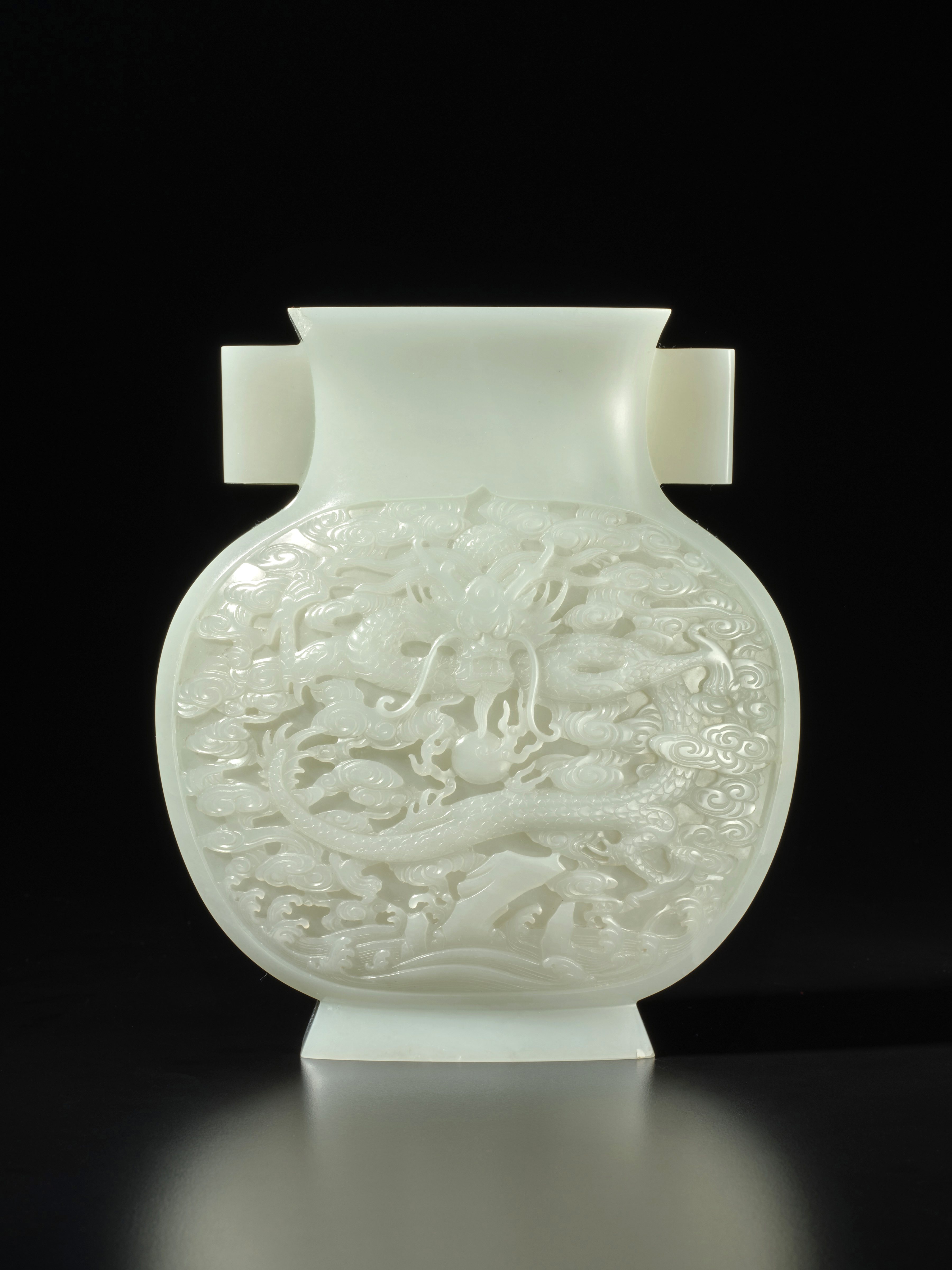 A superbly carved white jade 'dragon' vase, Qing dynasty, Qianlong period 清乾隆 白玉雕雲龍戲珠紋雙耳瓶