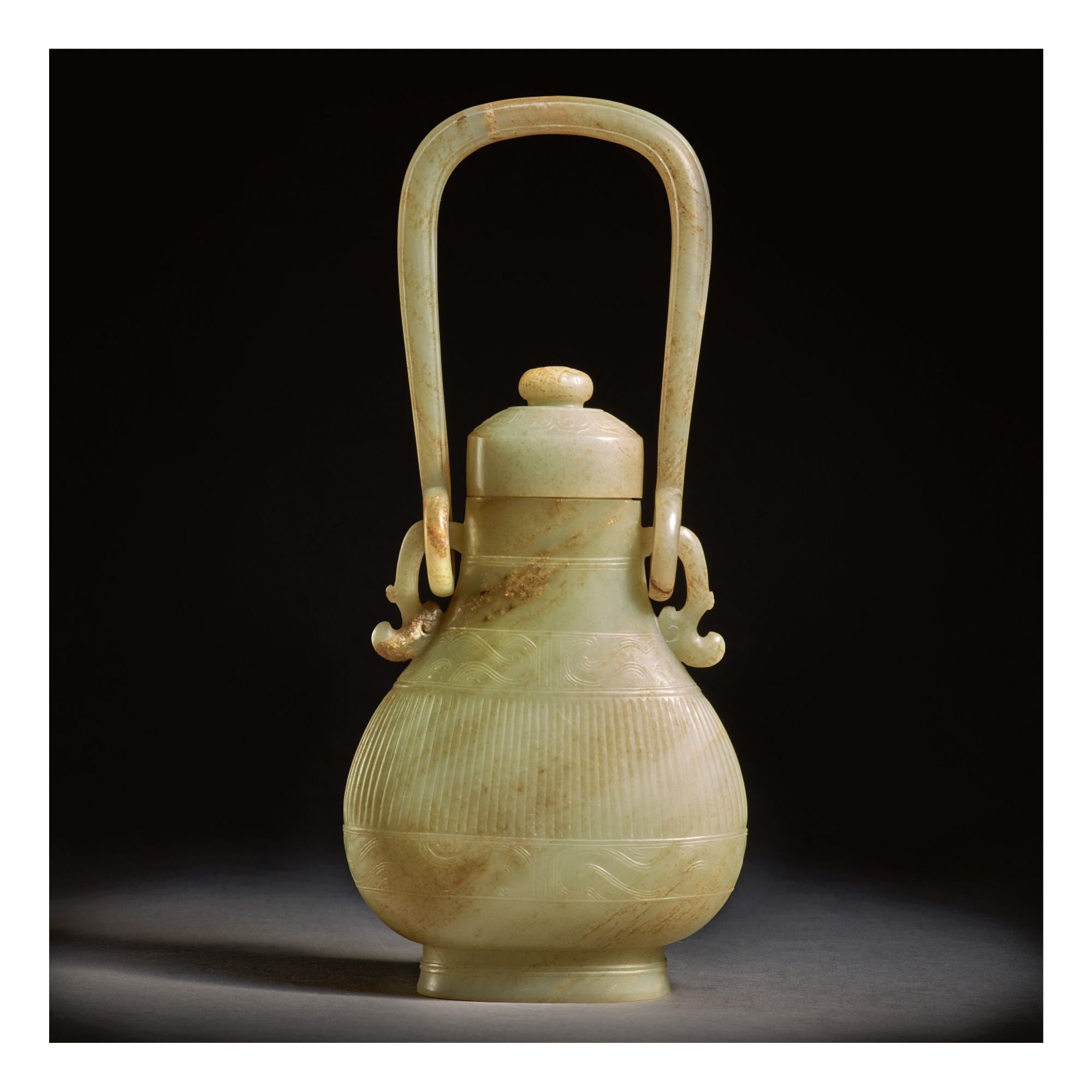 A CELADON AND RUSSET JADE ARCHAISTIC HANGING VASE AND COVER, 17TH