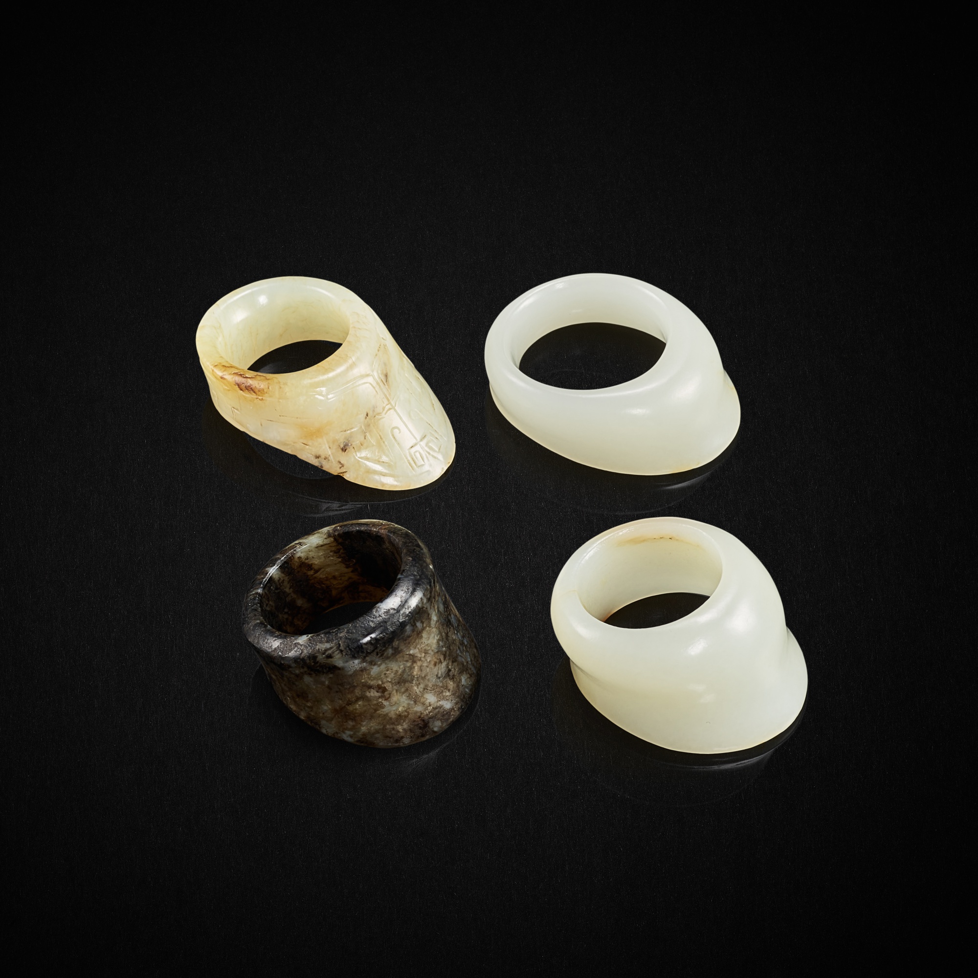 Three white jade archer's rings and a grey jade archer's ring, Qing dynasty, 17th - 18th century