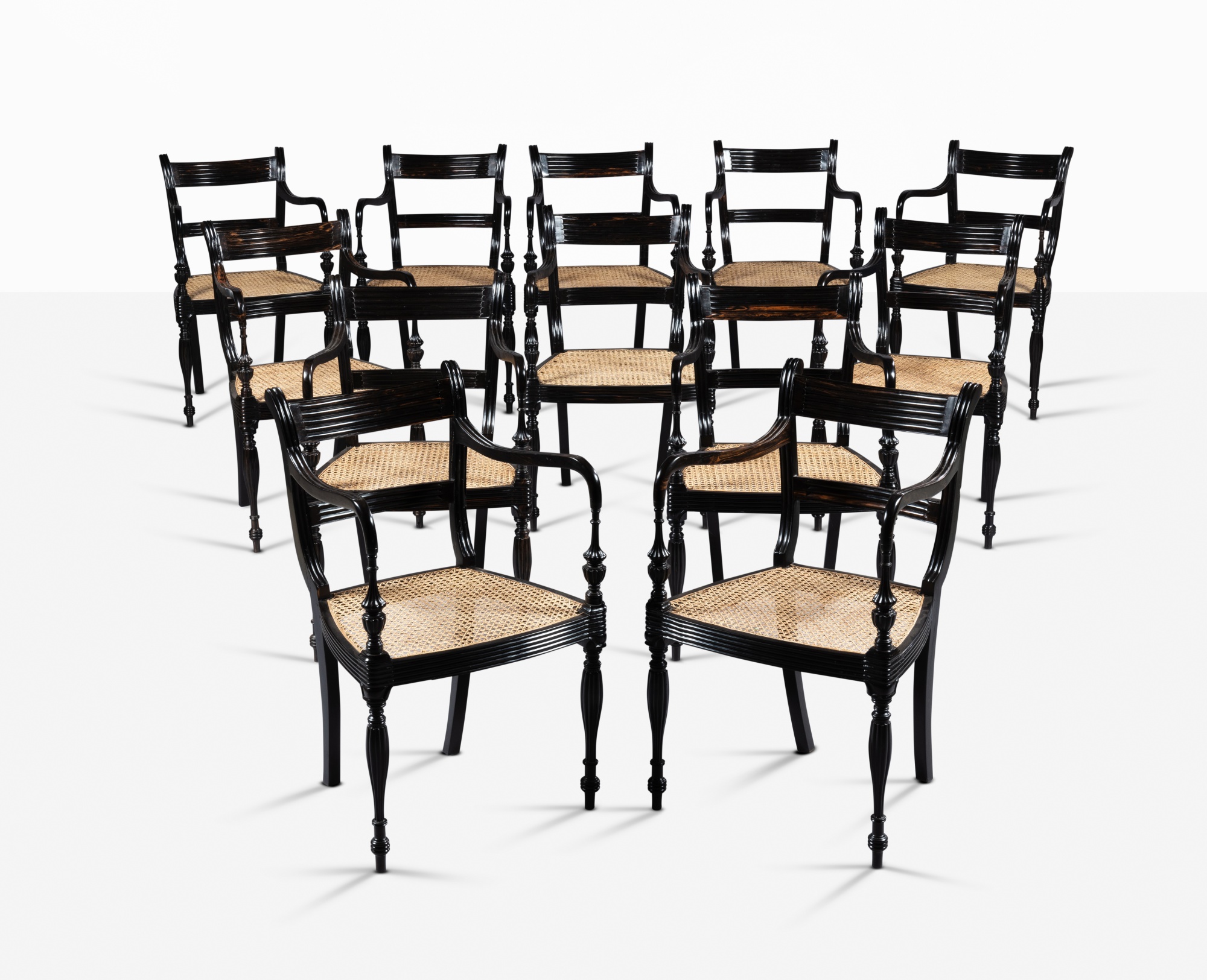 A set of twelve Anglo-Sinhalese style ebony armchairs, circa 2000