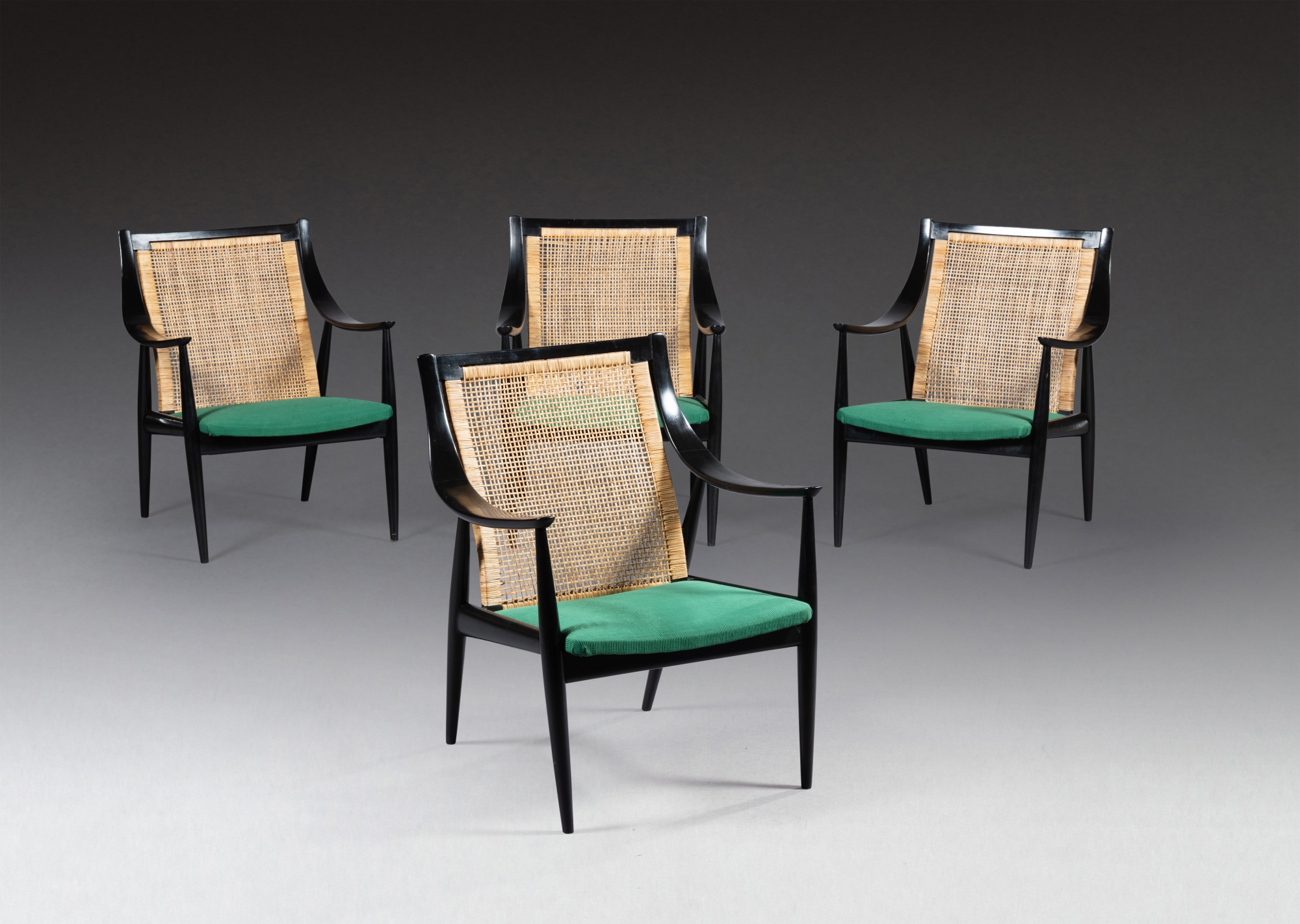A set of four caned ebony modernist armchairs by Chippendale, India