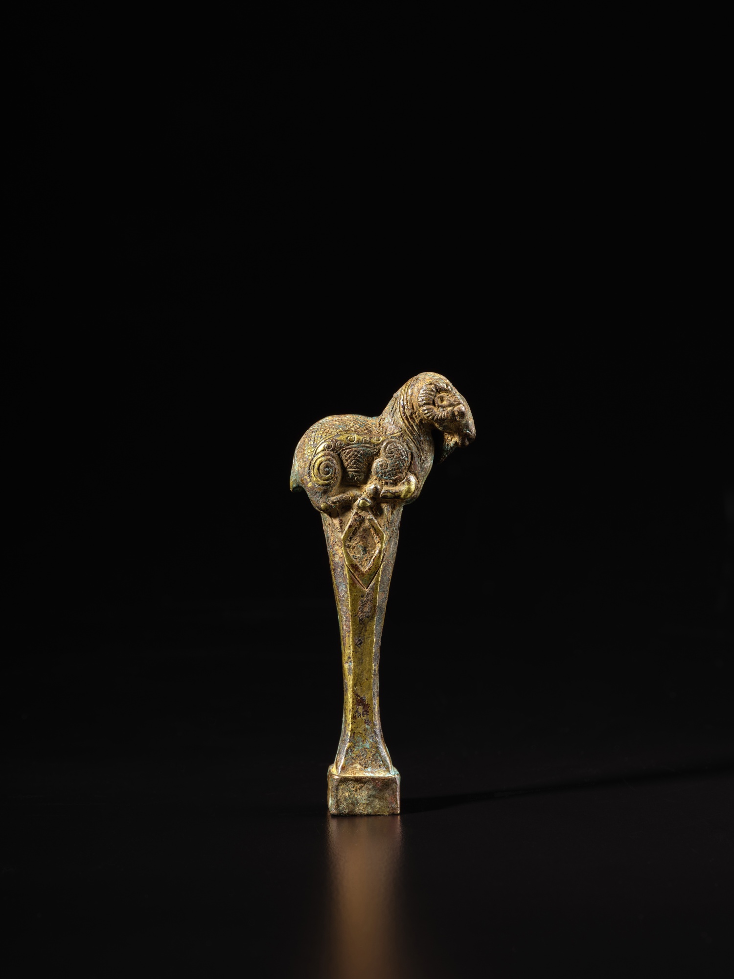 A giltcopper 'ram' zither tuning key, Eastern Zhou dynasty, Warring